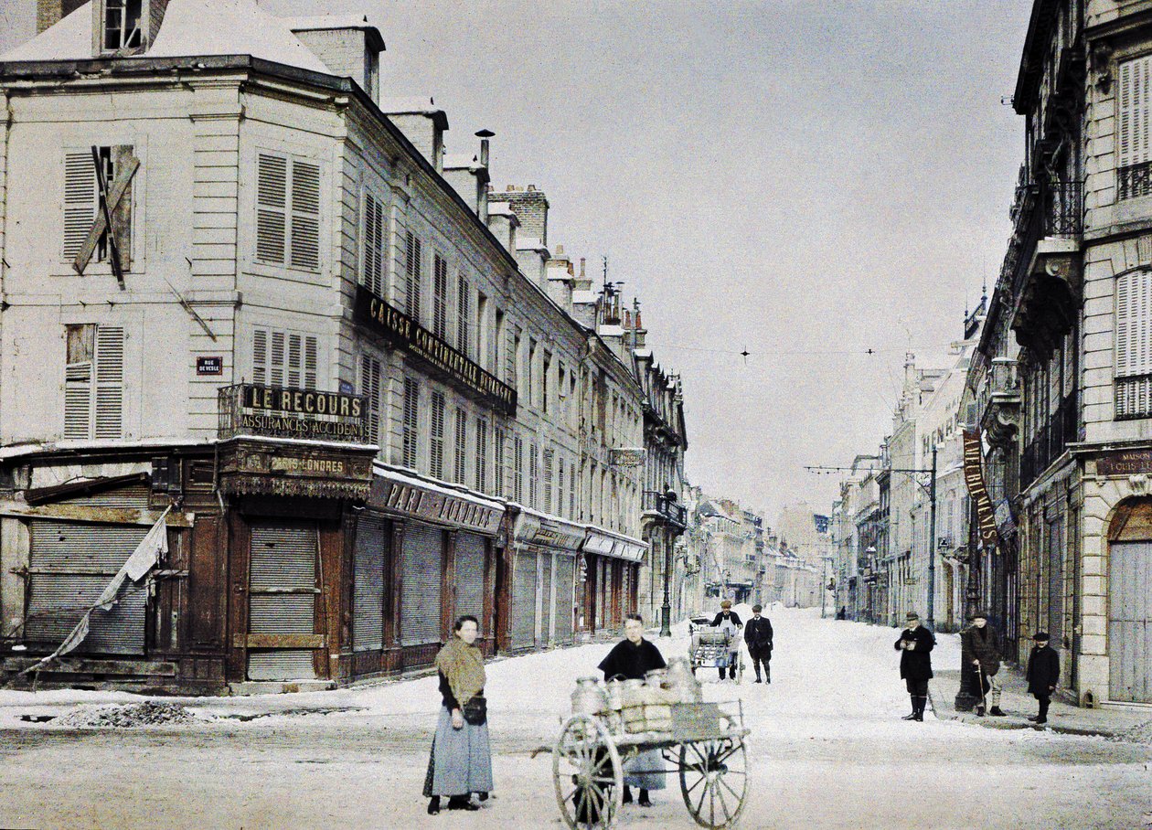 Una mujer con un carro lleno de latas de leche en Rue de Vesle y un hombre con otro carro en Rue de Talleyrand detrás de ella, Reims, Francia, 3 de marzo de 1917 (autocromo) de Paul Castelnau