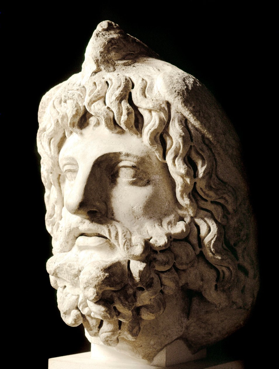 Arte romano: "cabeza barbada cubierta por un pájaro muerto de Sarapis o Serapis, dios greco-egipcio de la Muerte" Escultura de mármol de Cartago. Siglo II. Dim. 60 cm París, Museo del Louvre de Roman
