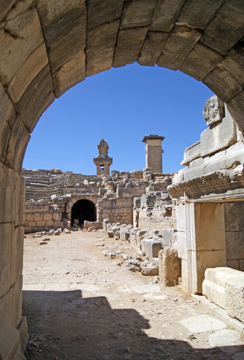 Vista a través de la entrada abovedada del teatro de Xanthos hacia el foso de la Orquesta, mostrando la columna y la tumba de Harpy, Xanthos, Turquía de Roman