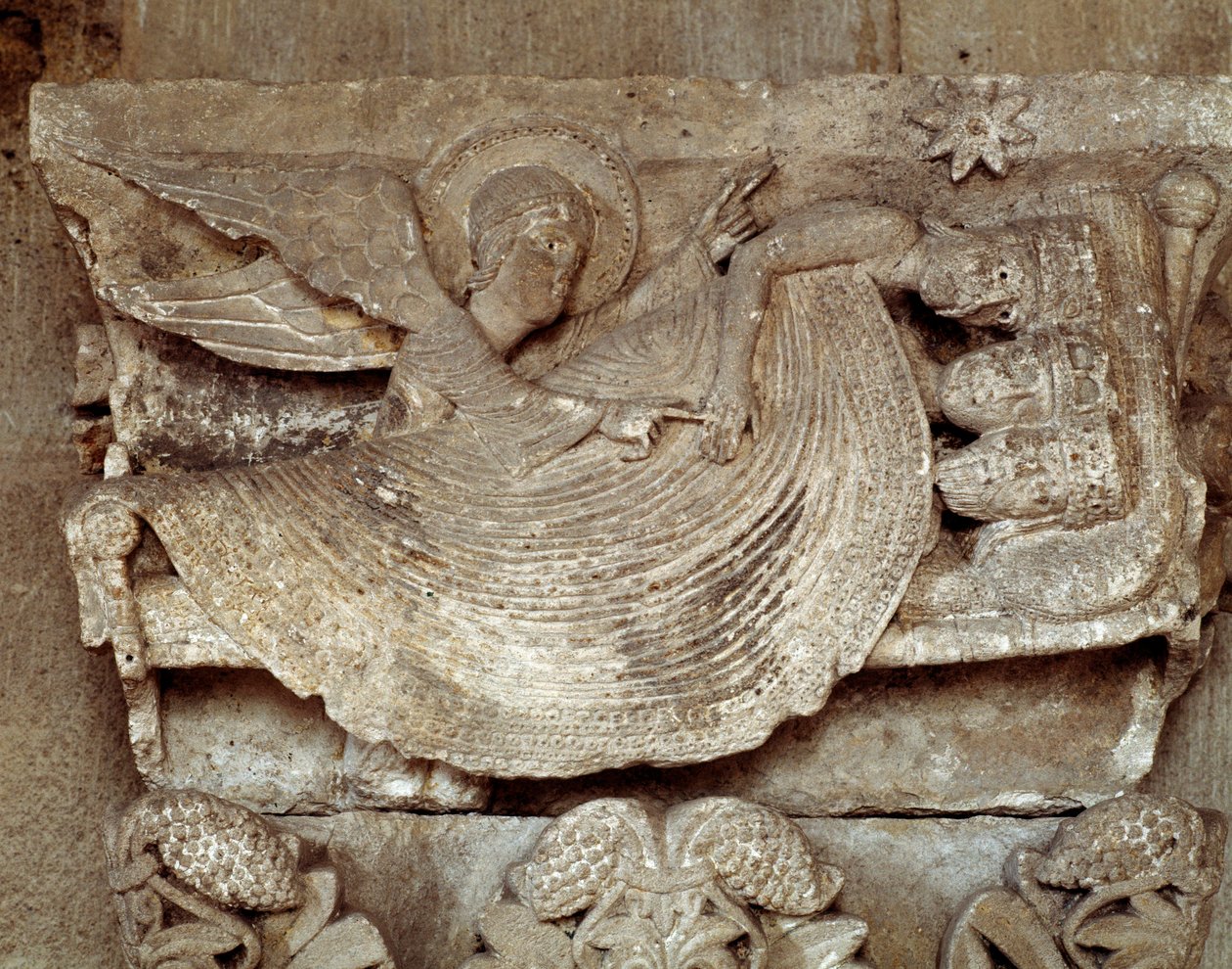 Los Reyes Magos dormidos con un ángel despertándolos y señalando hacia la estrella de Belén (capitel tallado) de Romanesque