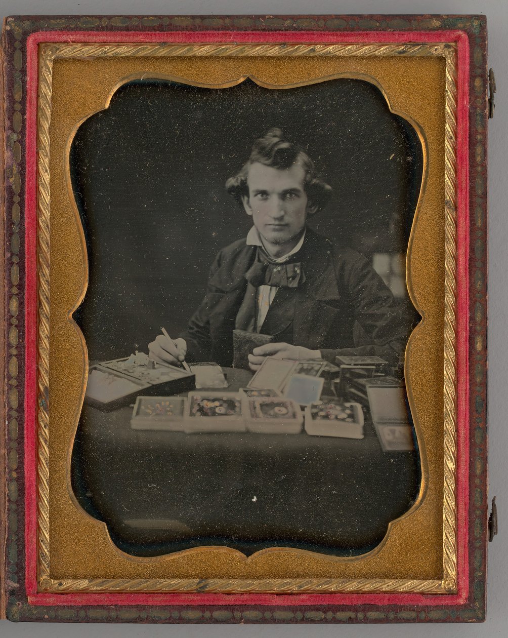 Retrato sin título de hombre sentado sosteniendo un daguerrotipo y un pincel, 1865 de Samuel J. Miller
