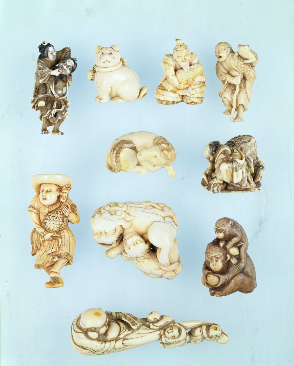 Selección de netsuke: Ikkuha Sennin llevando a la Prostituta de Benarés; cachorro sentado; Abe no Yasuneri sosteniendo un bebé; Gamma Sennin; caballo recostado; guerrero sometiendo a un buey fugitivo; holandés de pie sosteniendo un gallo de cola larga; sim de Japanese School