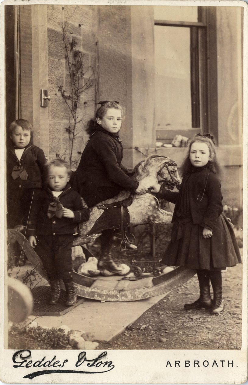 Grupo de niños pequeños y su caballo de juguete de Scottish Photographer