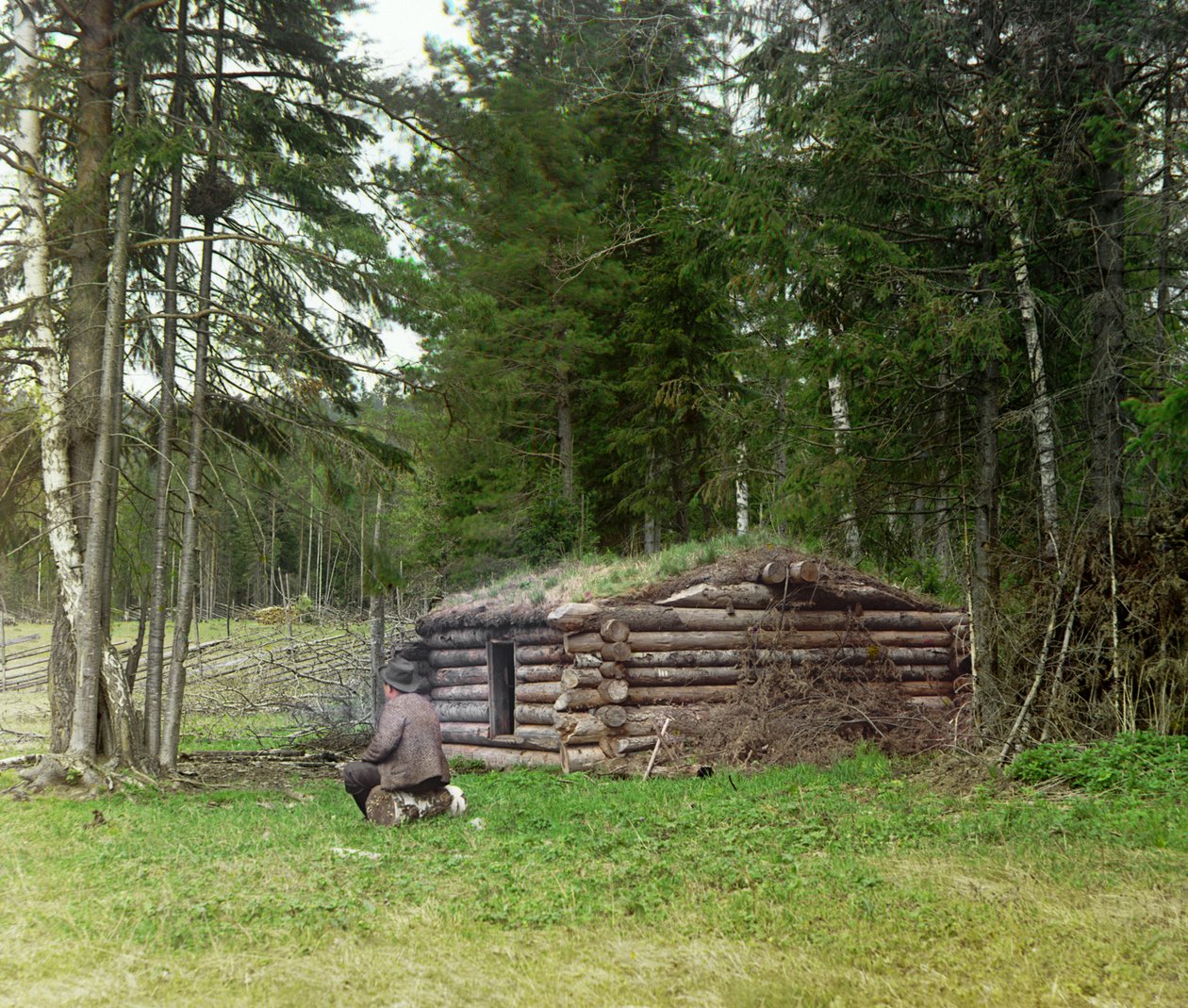 Un hombre frente a una cabaña para leñadores y kuria (quema de carbón) en el bosque, Imperio Ruso, entre 1905 y 1915 de Sergey Prokudin Gorsky