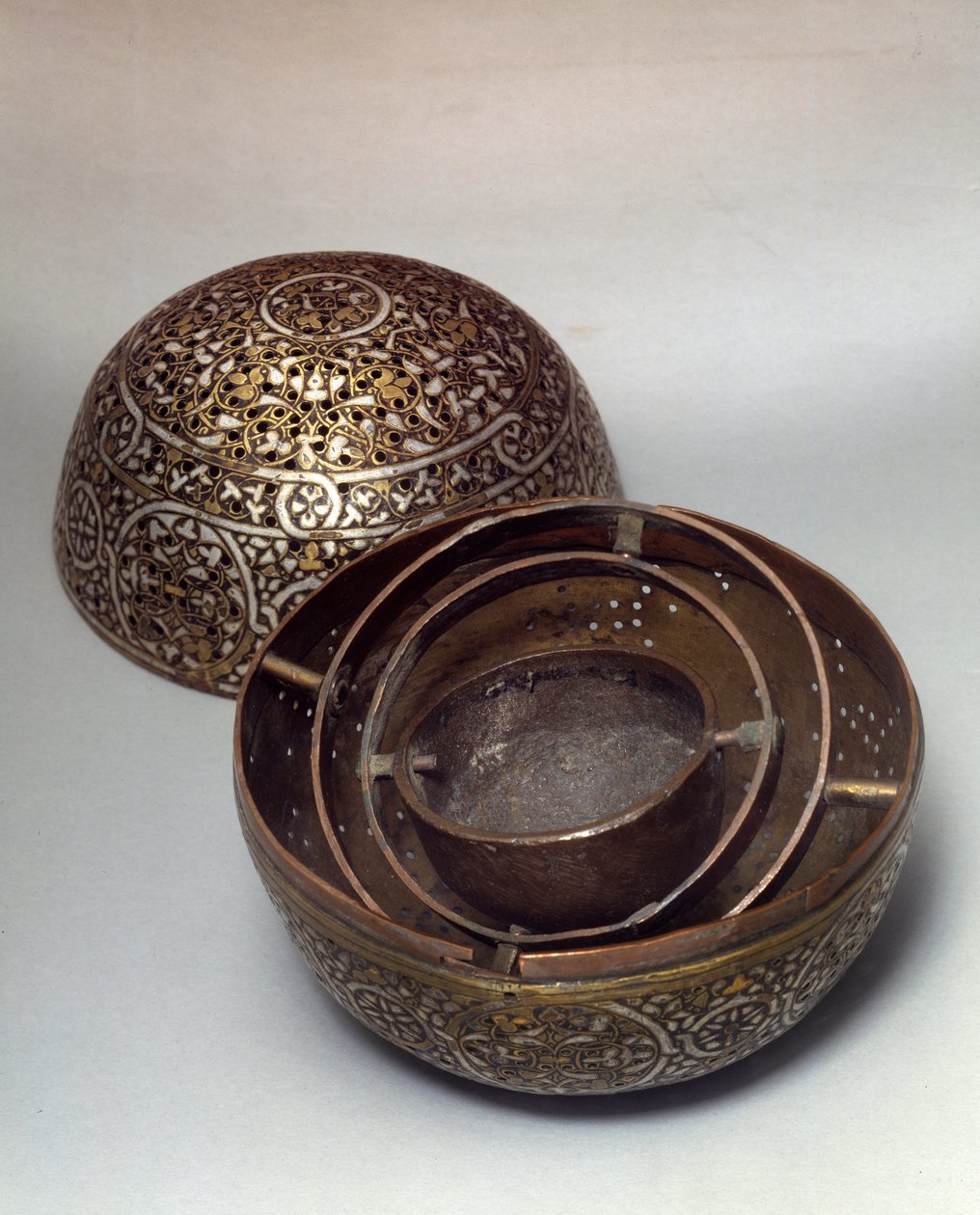 Arte Oriental: Perfume Burle o calentador de manos de Siria, finales del siglo XV, principios del siglo XVI. Aleación de cobre martillada con decoración grabada, perforada, incrustada con oro, plata y pasta negra. París, Museo del Louvre de Syrian School
