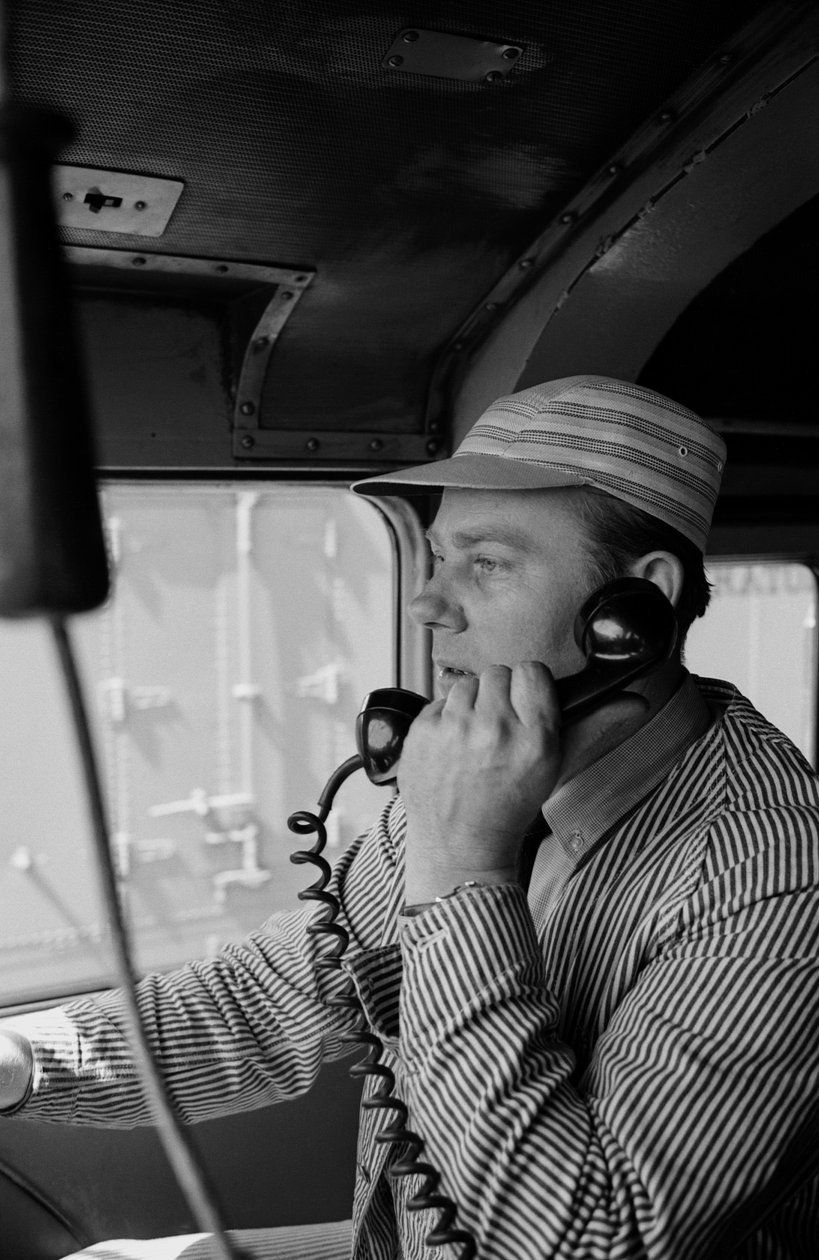 Charles Brockman, maquinista del Great Northern Railroad, habla por radioteléfono desde... de Ted Spiegel