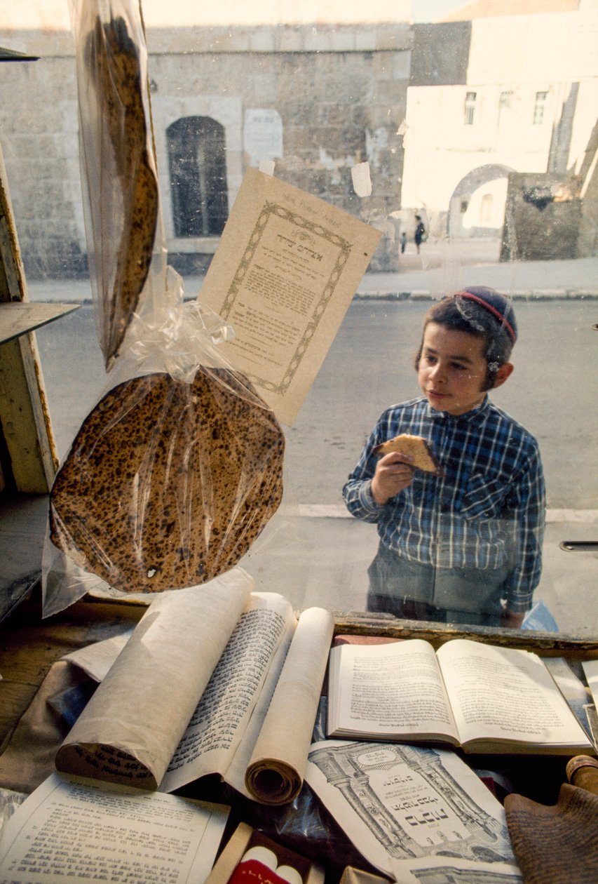 Niño judío conservador comiendo tarta se asoma a una librería religiosa. de Ted Spiegel