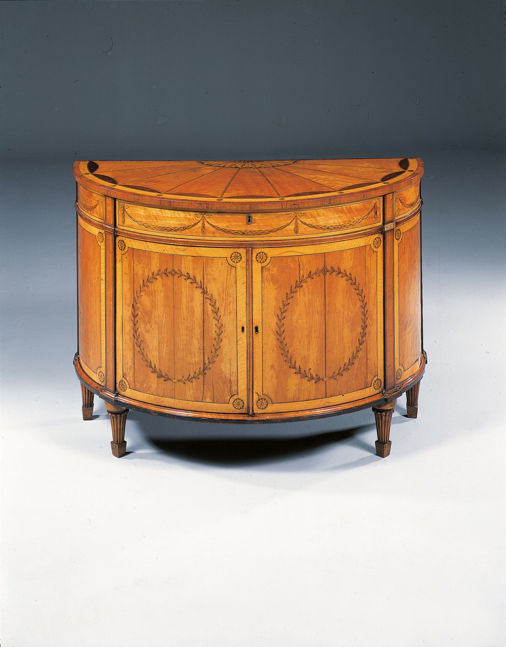 Cómoda semicircular de marquetería George III, c.1760-79 de Thomas (attr.to) Chippendale