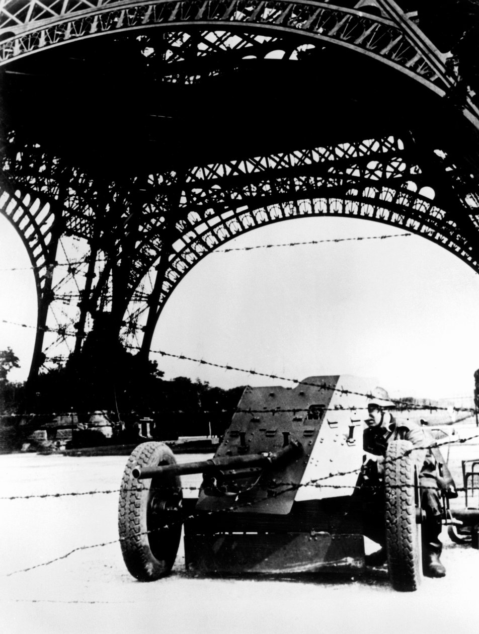 Alambre de púas y cañón antitanque bajo la Torre Eiffel, París ocupada por los alemanes, 1940-1944 de Unbekannt