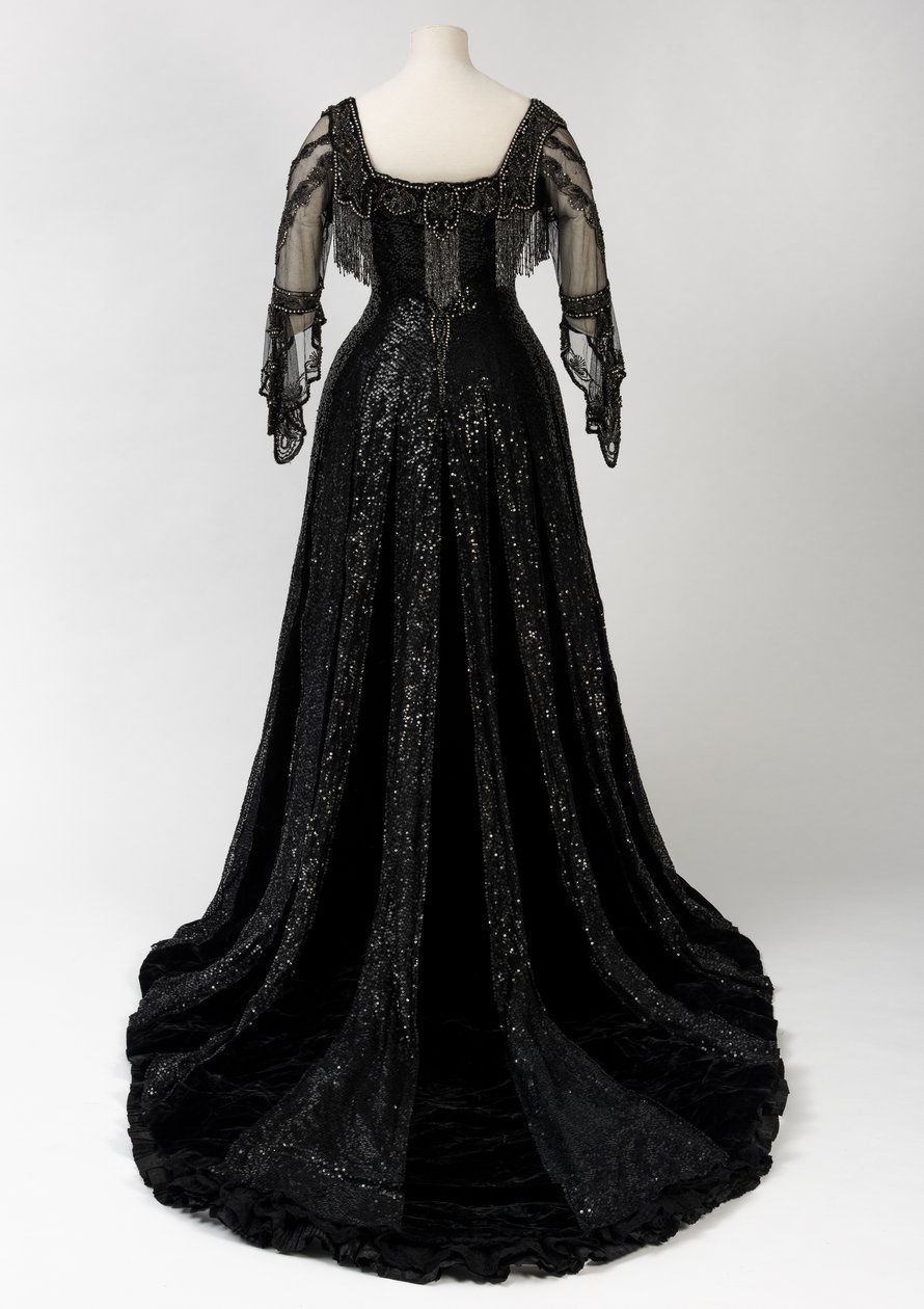 Vestido de noche negro de longitud completa usado por la Reina Alexandra, con decoración de cuentas y lentejuelas e incorporando la cinta de nombre de seda negra y letras doradas de la Reina Alexandra, hecho por Barolet de Knightsbridge, Londres 1908-1910 de Unbekannt