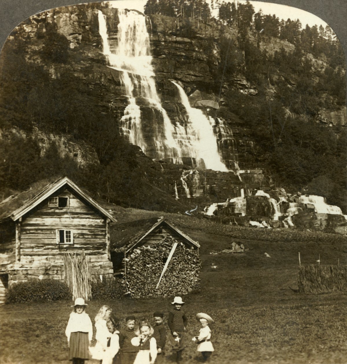 Niños jugando en un campo de agricultores con la cascada en terrazas Tvinde, Vossevangen, Noruega, c. 1905 de Unbekannt