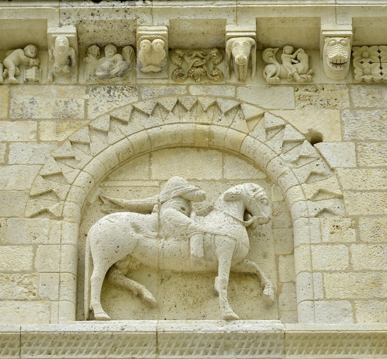 Arte románico: detalle de la fachada que representa a Hugues de Surgeres y Geoffroy de Vendome o al emperador Constantino I el Grande cuyo pie del caballo pisaría la herejía y Cristo triunfante del mal y la muerte, Notre Dame de Surgeres de Unbekannt