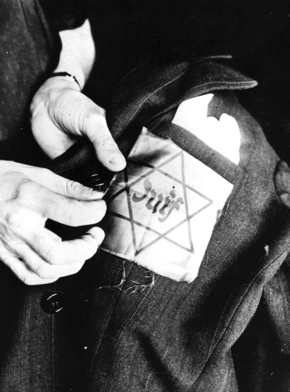 Cosiendo la estrella amarilla que identifica a un judío en una chaqueta, París ocupada por los alemanes, 1942 de Unbekannt