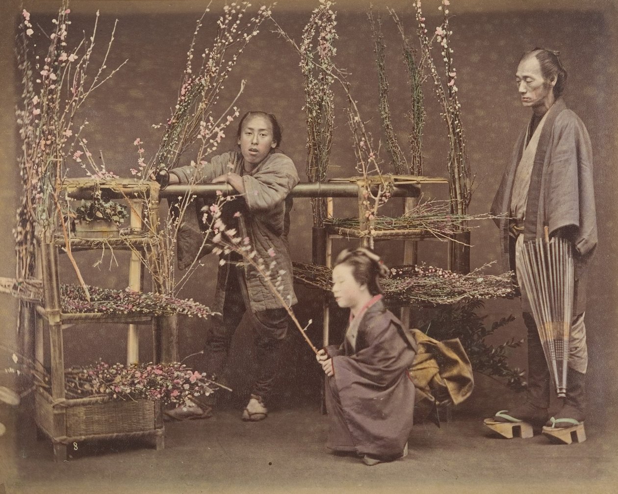[Dos hombres japoneses y una mujer japonesa posando con ramas florecientes], 1870s de Unbekannt