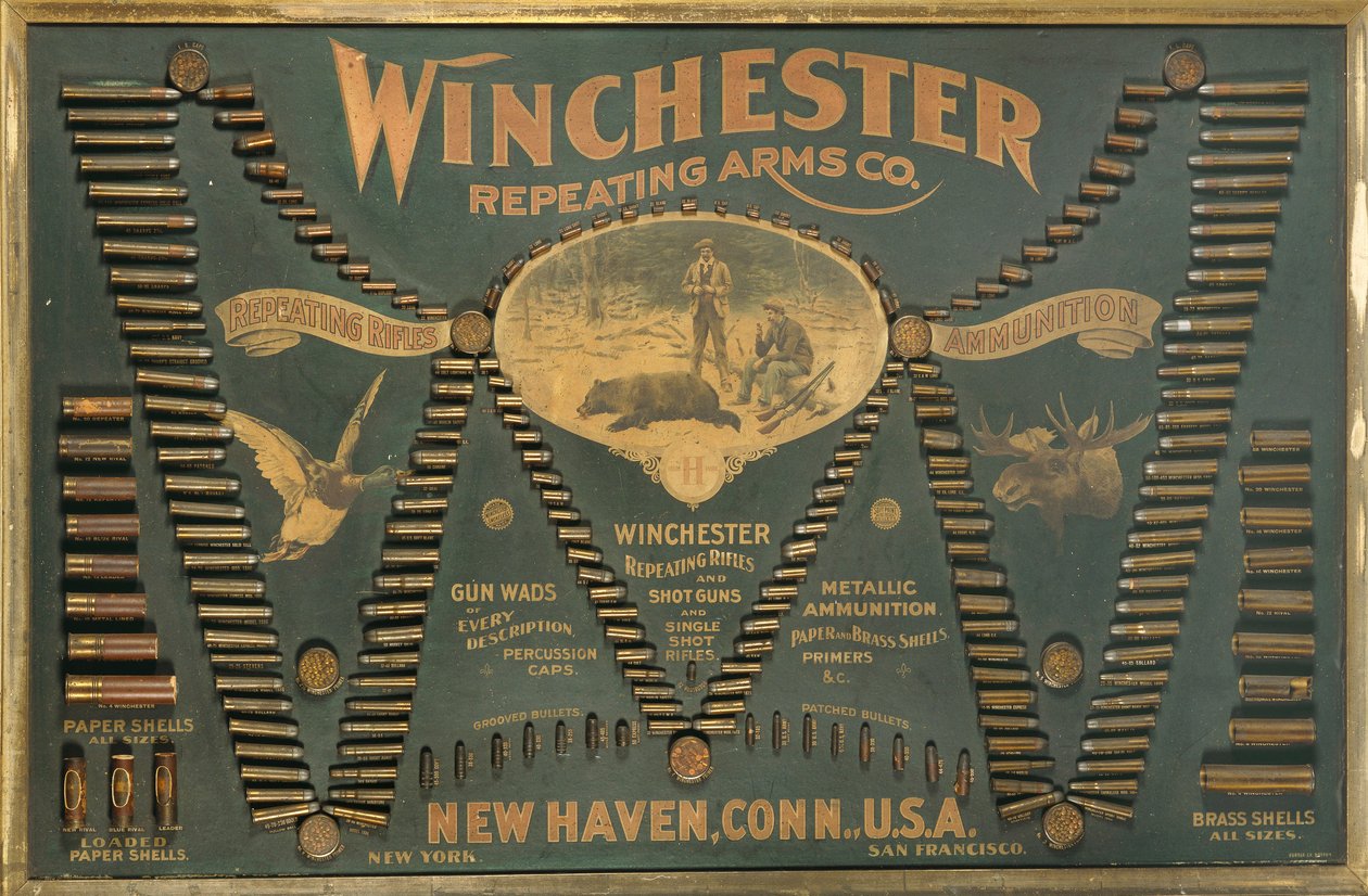 Tablero de exhibición de cartuchos Winchester, con una selección completa de cartuchos de rifle metálicos, de latón y de papel dispuestos en forma de una "W" extendida de Unbekannt