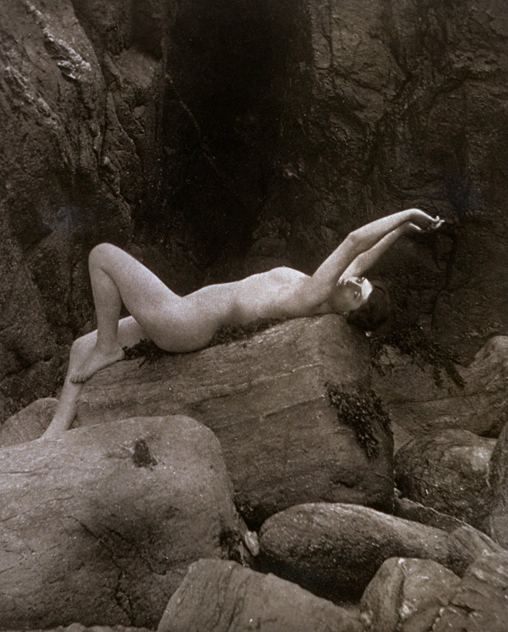 Una joven desnuda en pose artística recostada sobre una roca de Unbekannter Künstler