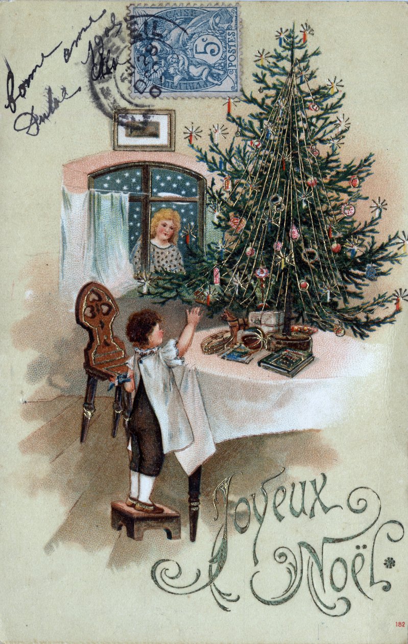 Tarjeta de felicitación navideña: un niño frente a un árbol de Navidad posa sobre una mesa, observado por un ángel en la ventana - Postal fechada en 1905 de Unbekannt