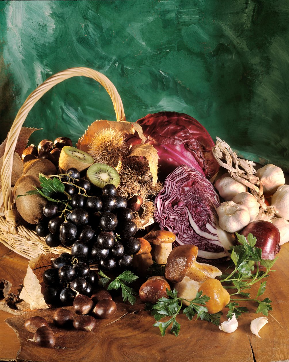 Dieta: bodegón de uvas negras, ajo, cebolla, diente de ajo, perejil, champiñón, castaña, kiwi y col roja de William M. Timlin