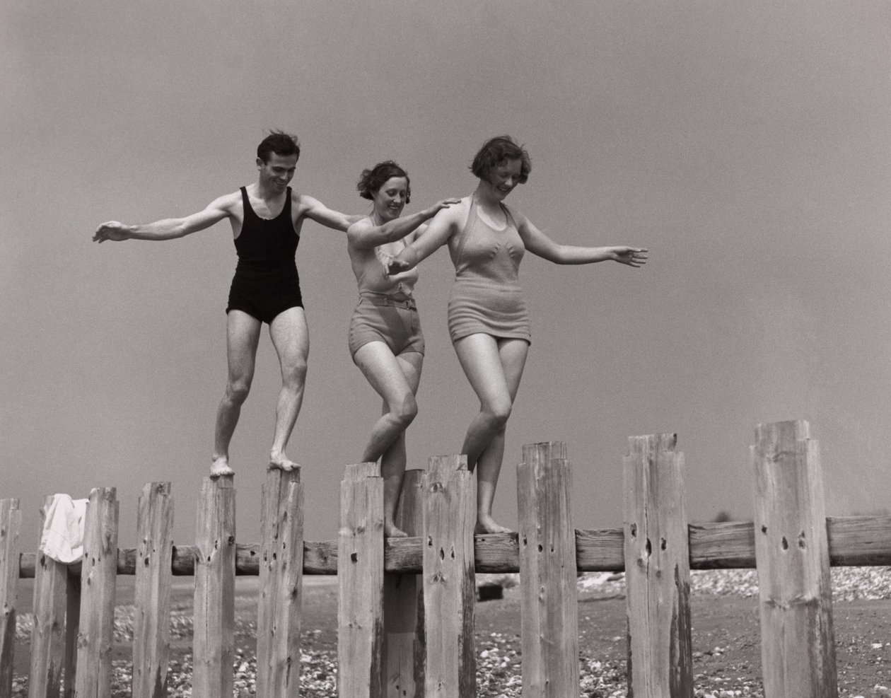 Dos mujeres y un hombre caminando por un espigón, c 1930s de Unbekannt