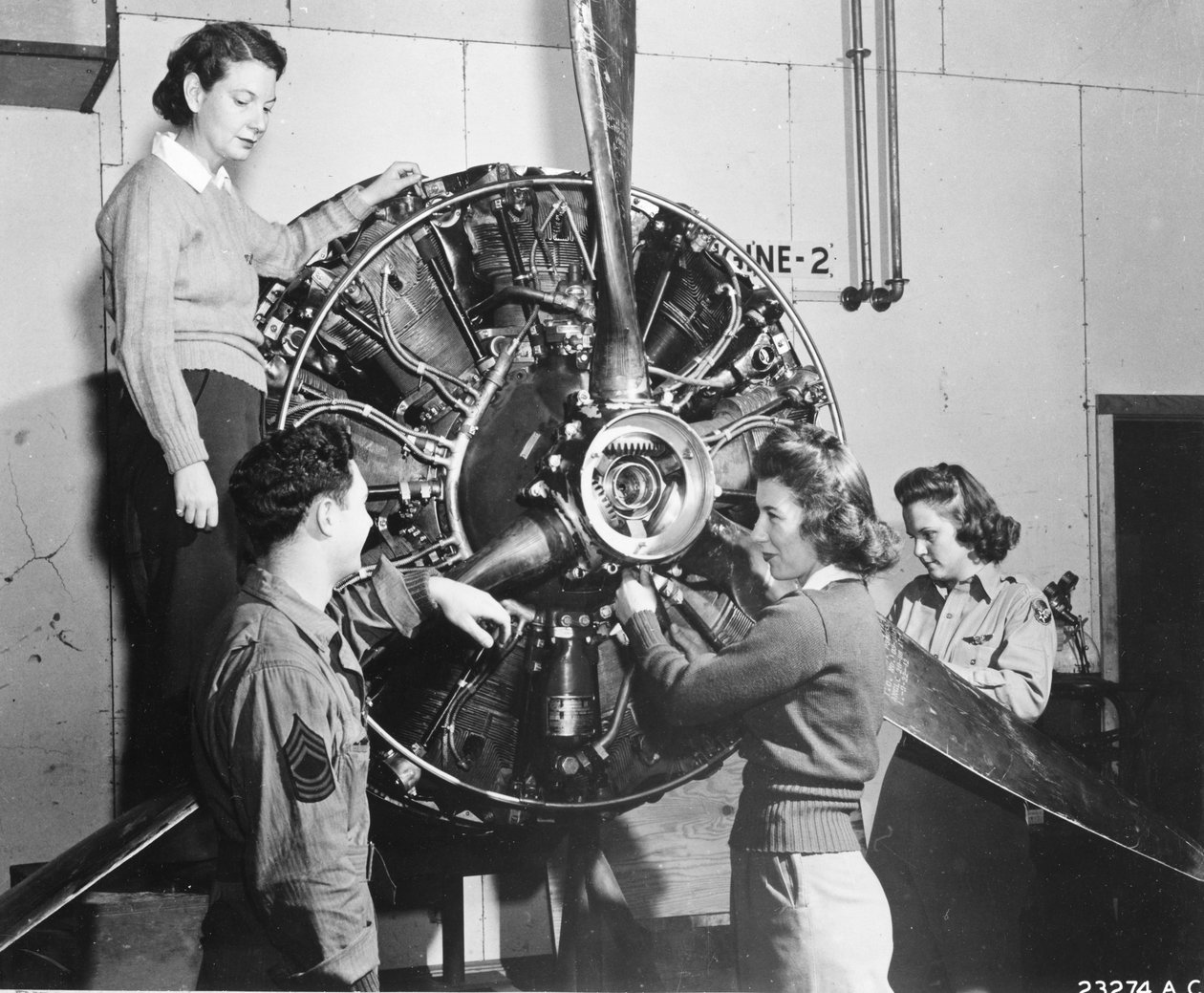 Las avispas aprenden de dónde viene el poder en el motor del B-17 Flying Fortress mientras asisten al entrenamiento de pilotos de B-17 en Lockbourne AAB, trabajando en el mecanismo de la hélice, mientras un jefe de equipo observa, son (de izquierda a derec de Benjamin Baud
