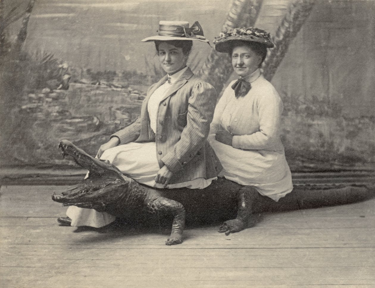 Mujer sentada sobre un caimán disecado, c.1905 (foto b/n) de Unbekannter Künstler