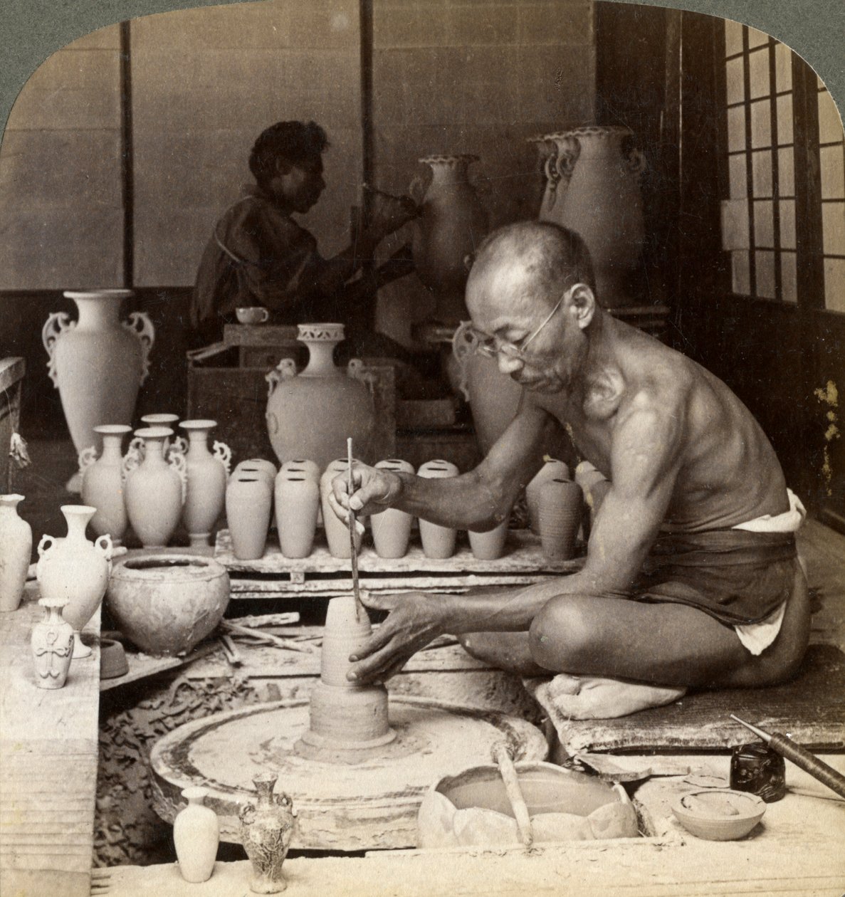 Un alfarero y su rueda, modelando un jarrón de porcelana Awata, obras de Kinkosan, Kioto, Japón, 1904 de Underwood and Underwood