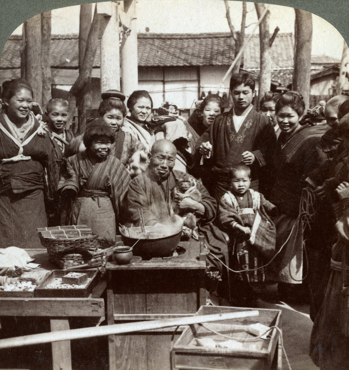 Un artista callejero con un mono divirtiendo a la multitud, Kobe, Japón, 1896 de Underwood and Underwood