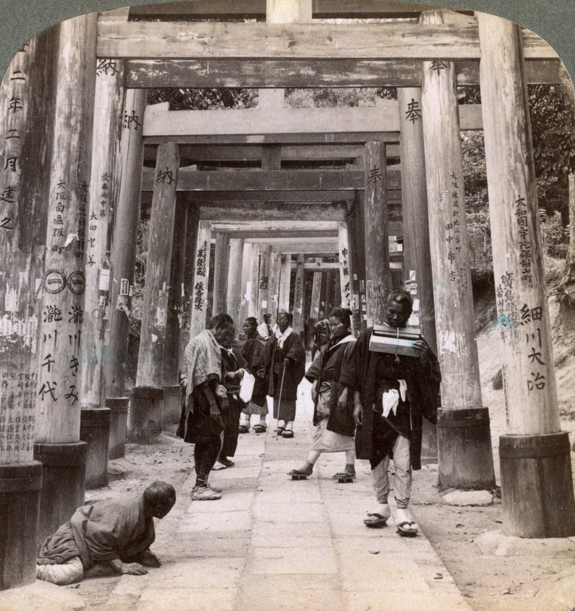 Entrando y saliendo bajo largas filas de torii sagrados, templo sintoísta de Inari, Kioto, Japón, 1904 de Underwood and Underwood