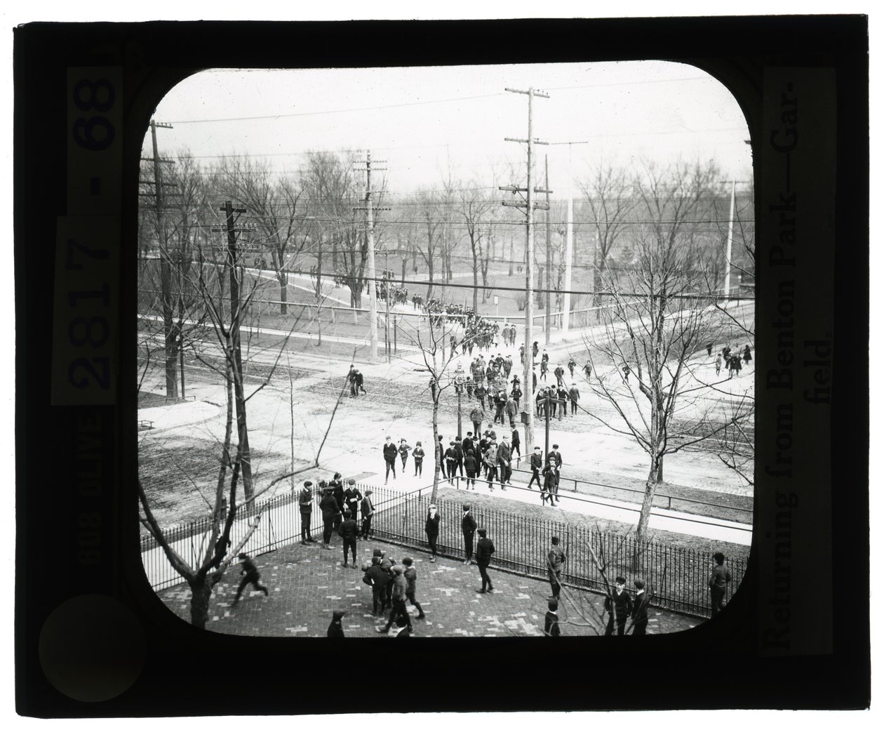 Foto horizontal en blanco y negro de niños y niñas cruzando la calle para regresar a la escuela después de un viaje al parque de Unknown