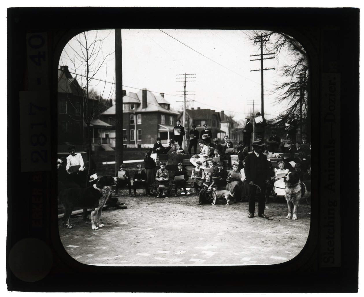 Foto horizontal en blanco y negro de estudiantes dibujando perros en un aula al aire libre de Unknown