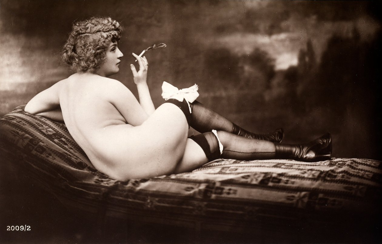 Retrato de una joven que posa desnuda, de espaldas, mientras fuma un cigarrillo de Unknown photographer