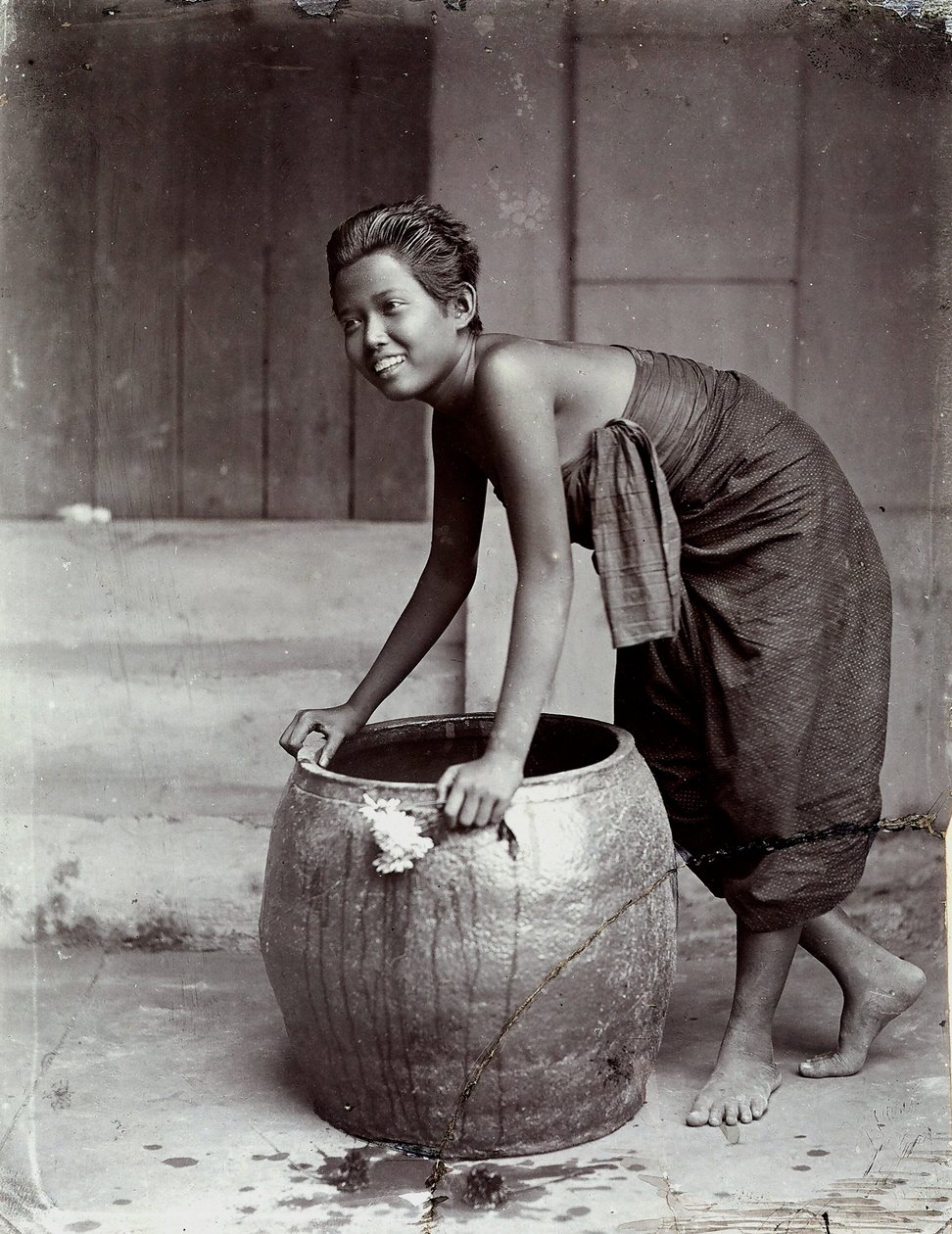 Joven tailandesa sonriente, empujando un gran contenedor de Unknown photographer