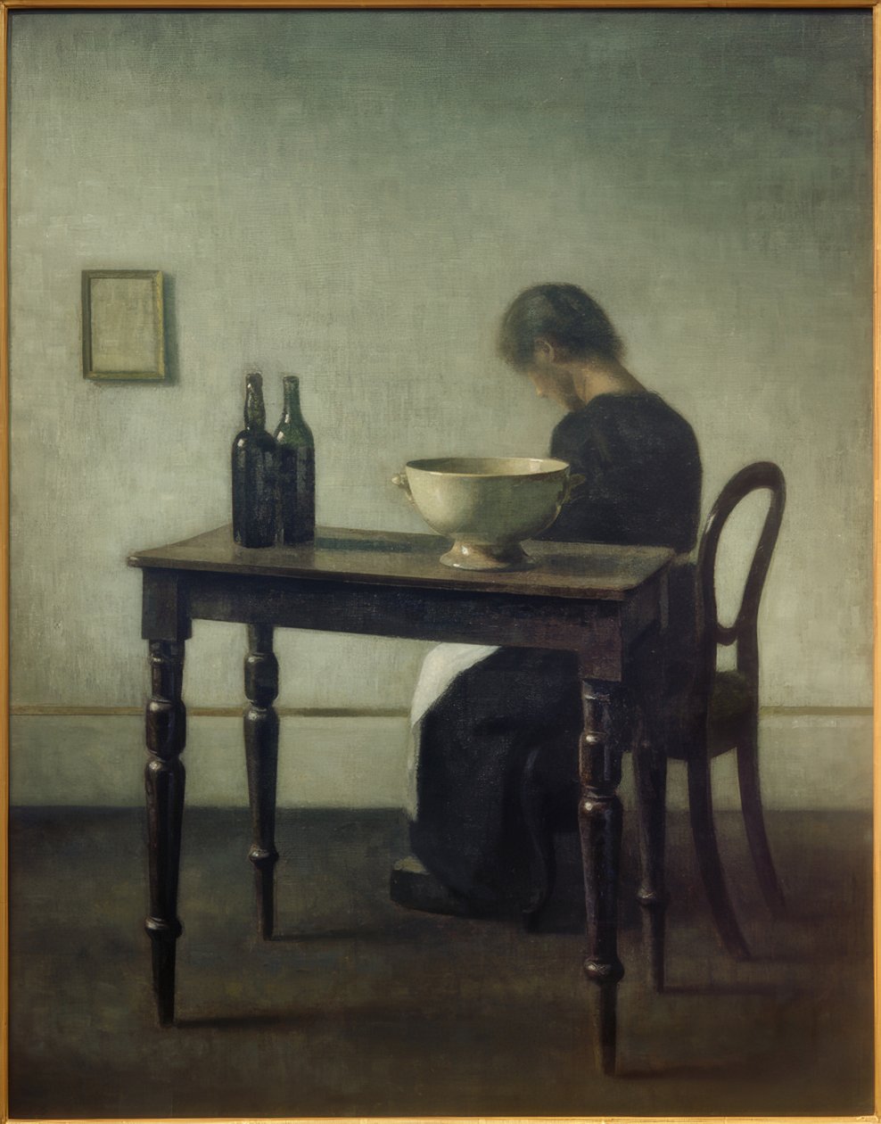 Mujer sentada detrás de una mesa de Vilhelm Hammershoi