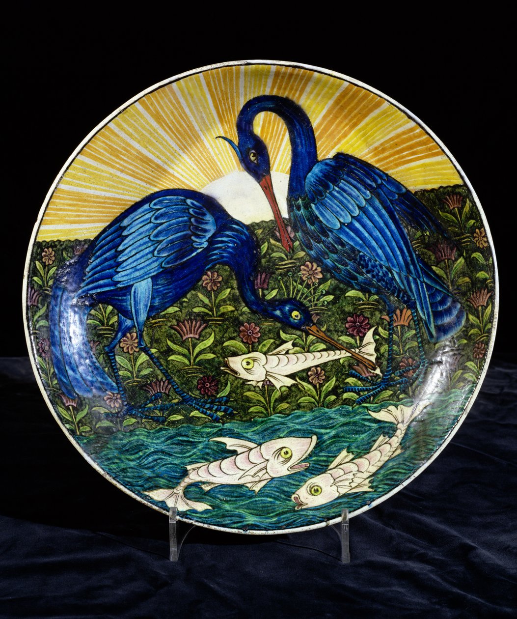 Plato con dos garzas pescando en la orilla de un río, pintado por Charles Passenger de William de Morgan