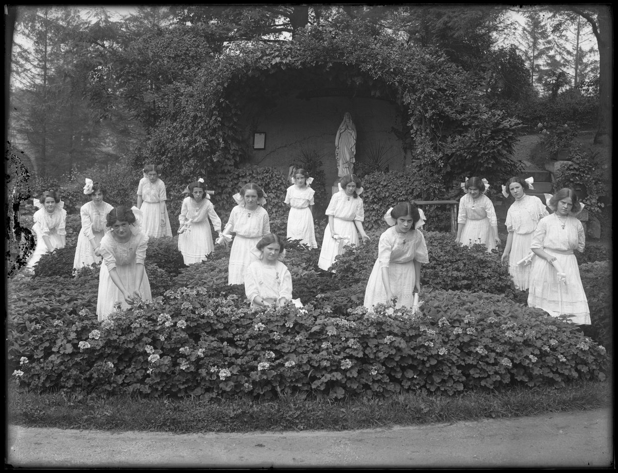 Clase graduada de niñas del Asilo de Huérfanos Católico Romano en el jardín de flores, frente a la gruta de la Virgen María, 1912 de William Davis Hassler