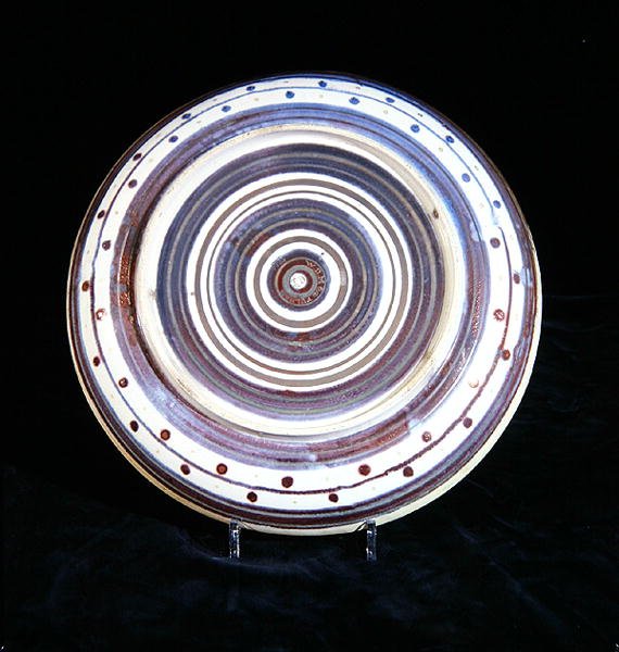 Plato con círculos concéntricos de blanco, azul, púrpura y oro, pintado por Charles Passenger de William de Morgan