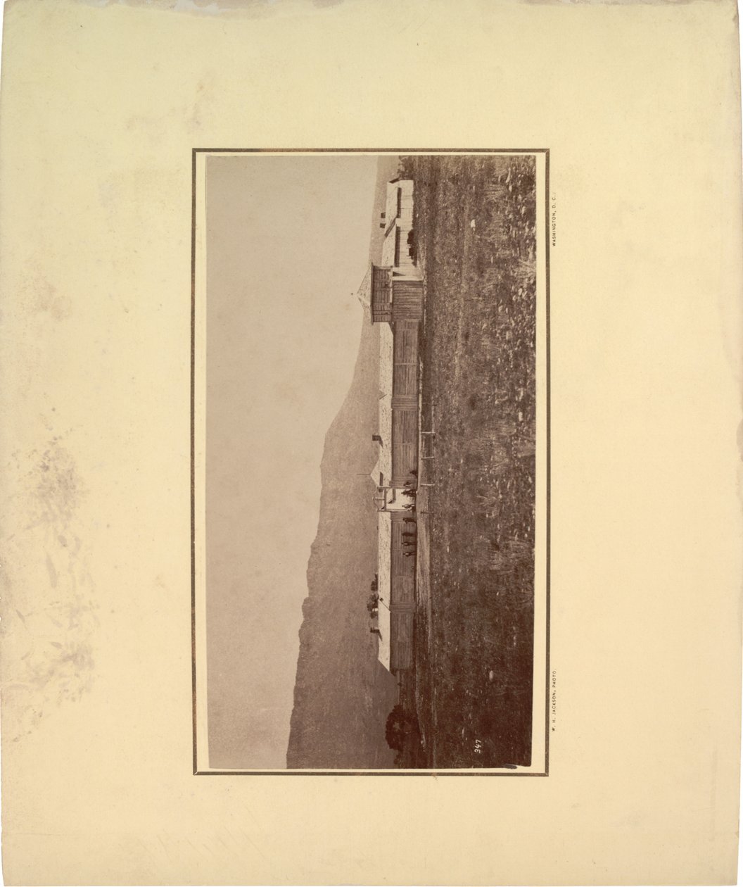 Vista de una empalizada con varios hombres reunidos en la puerta de entrada, 1871 de William Hicks Jackson