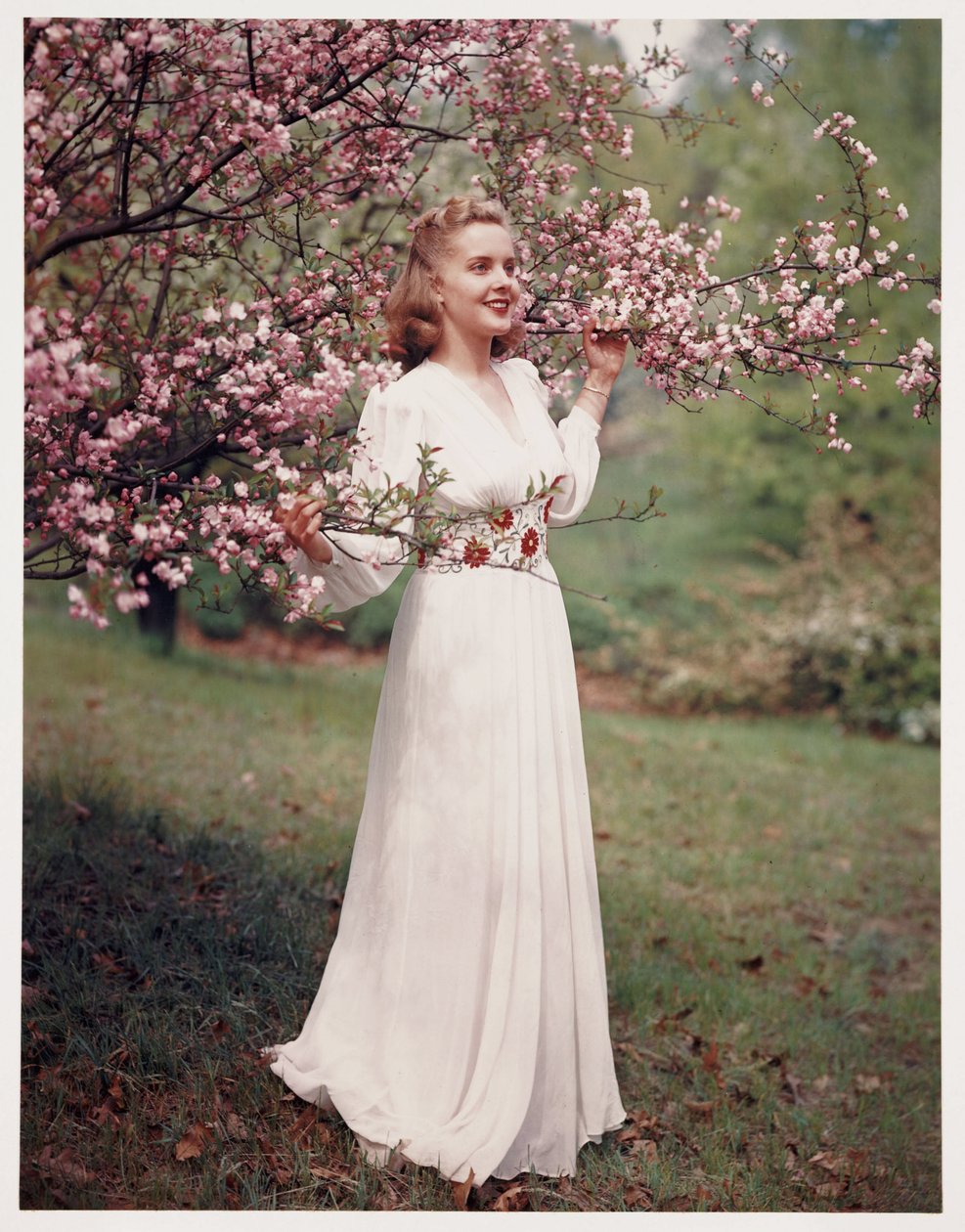 Mujer modelando un vestido cerca de flores, c. 1940s de Frederick (attr. to) Barnard