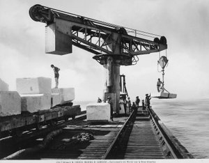 Cargando bloques de mármol con una grúa hidráulica en Marina di Carrara (foto en b/n)