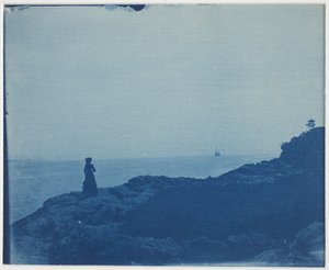 Mujer observando goleta desde un promontorio rocoso de American Photographer