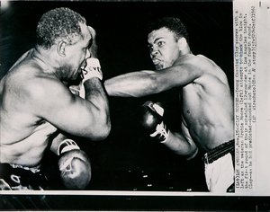 El joven Cassius Clay golpea con la izquierda al veterano Archie Moore en el primer asalto de la pelea en Los Ángeles de American Photographer