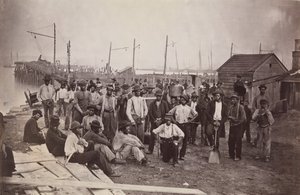 Trabajadores en el muelle del intendente, Alexandria, Virginia, 1863-65 de Andrew Joseph Russell.