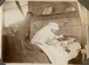 Primera Guerra Mundial 1914-1918: enfermera en bata afeitando a un soldado (herido de guerra francés en una cama), en Couville, Mancha, Baja Normandía, Francia. Fotografía anónima julio 1917. Colección privada, Stella. de Anonymous Anonymous