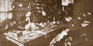 En la cabaña, en pleno invierno, los hombres se dedican a coser pieles para la ropa que se utilizará en la primavera en trineo, pub. Londres 1907 (foto en blanco y negro) de Anthony Fiala