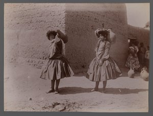 Dos mujeres llevando jarras de barro sin usar medias de Antoin Sevruguin