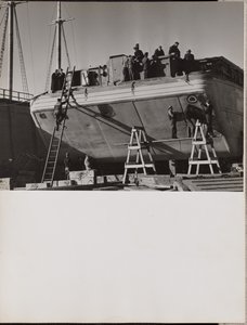 [Un grupo de hombres trabajan en un barco atracado]