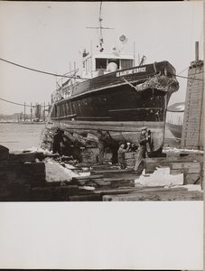 [Cuatro hombres reparan la mitad inferior de un barco atracado] de Arnold Eagle