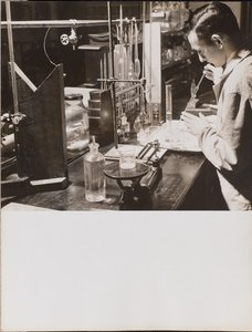[Un hombre en un laboratorio utiliza ambas manos para colocar una gran pipeta en un vaso de precipitados].