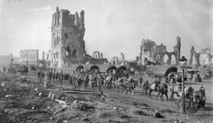 Una sección de ametralladoras australiana no identificada con caballos cargados pasando por las ruinas del Cloth Hall. Nótese varios camiones estacionados en el fondo, 19 de octubre de 1917 de Australian Photographer