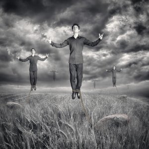 Hombres levitando bajo un cielo tormentoso